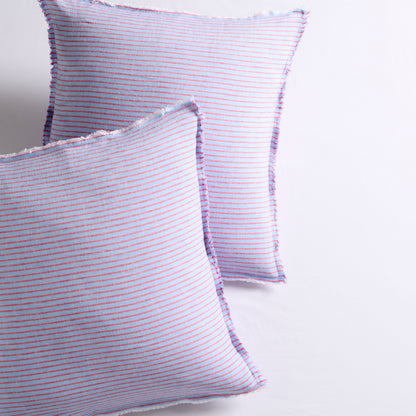 Two blue linen Euro shams with thin red stripes and frayed edges.