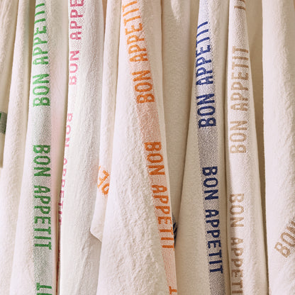 Set of 2 white linen hand towels with "Bon Appetit" in green, pink, orange, blue, and brown text.