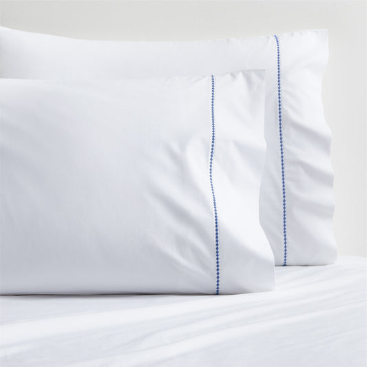 Set of 2 white percale pillowcases with blue diamond embroidered detail.