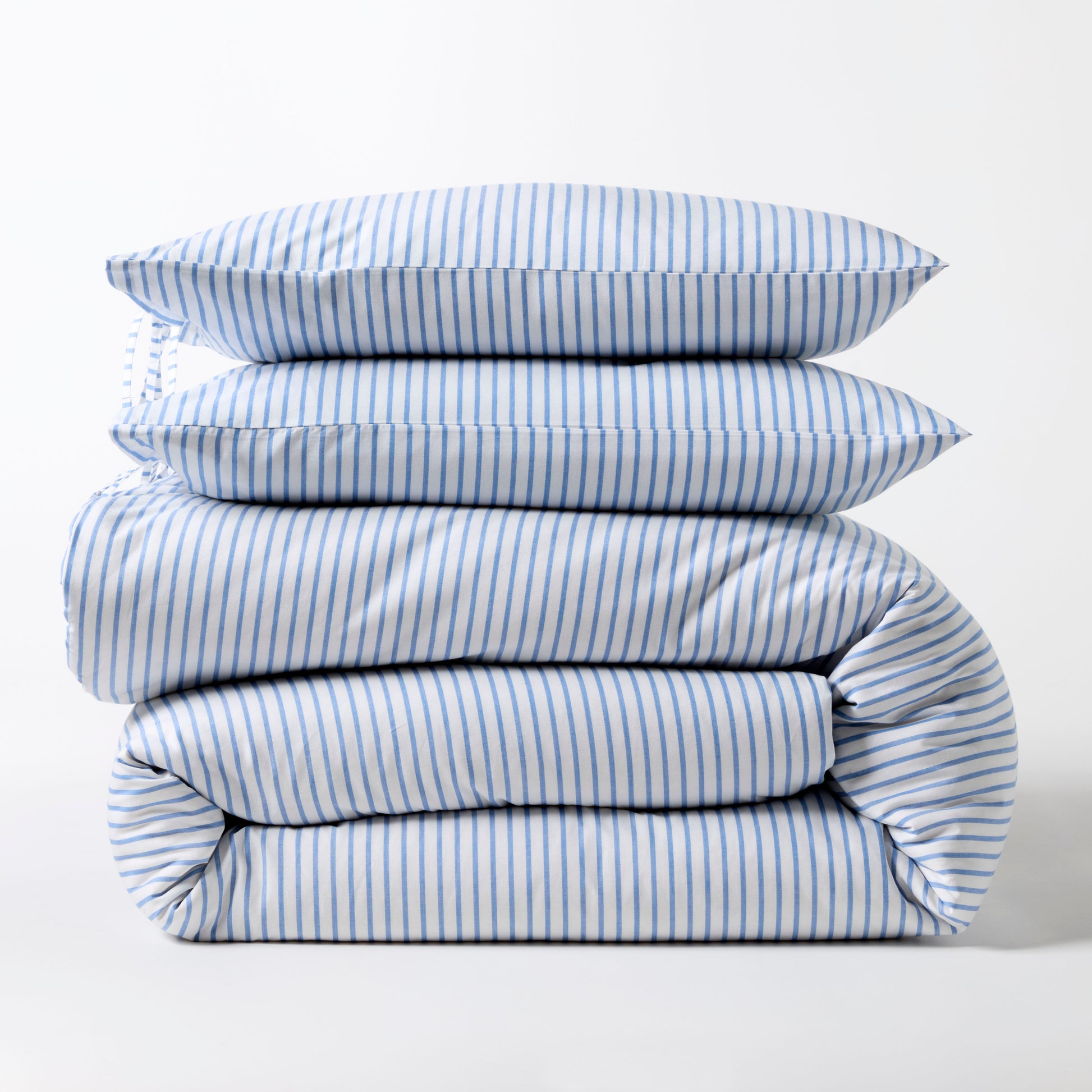 Stacked blue oxford thin stripe organic cotton duvet and shams set with tie closures.