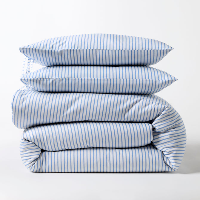 Stacked blue oxford thin stripe organic cotton duvet and shams set with tie closures.