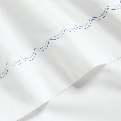 White percale sheet with a blue scallop-stitch detail along the edge.