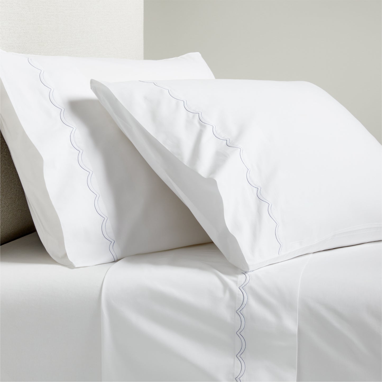 White percale sheet set with blue scallop stitch detail on pillowcases and flat sheet.