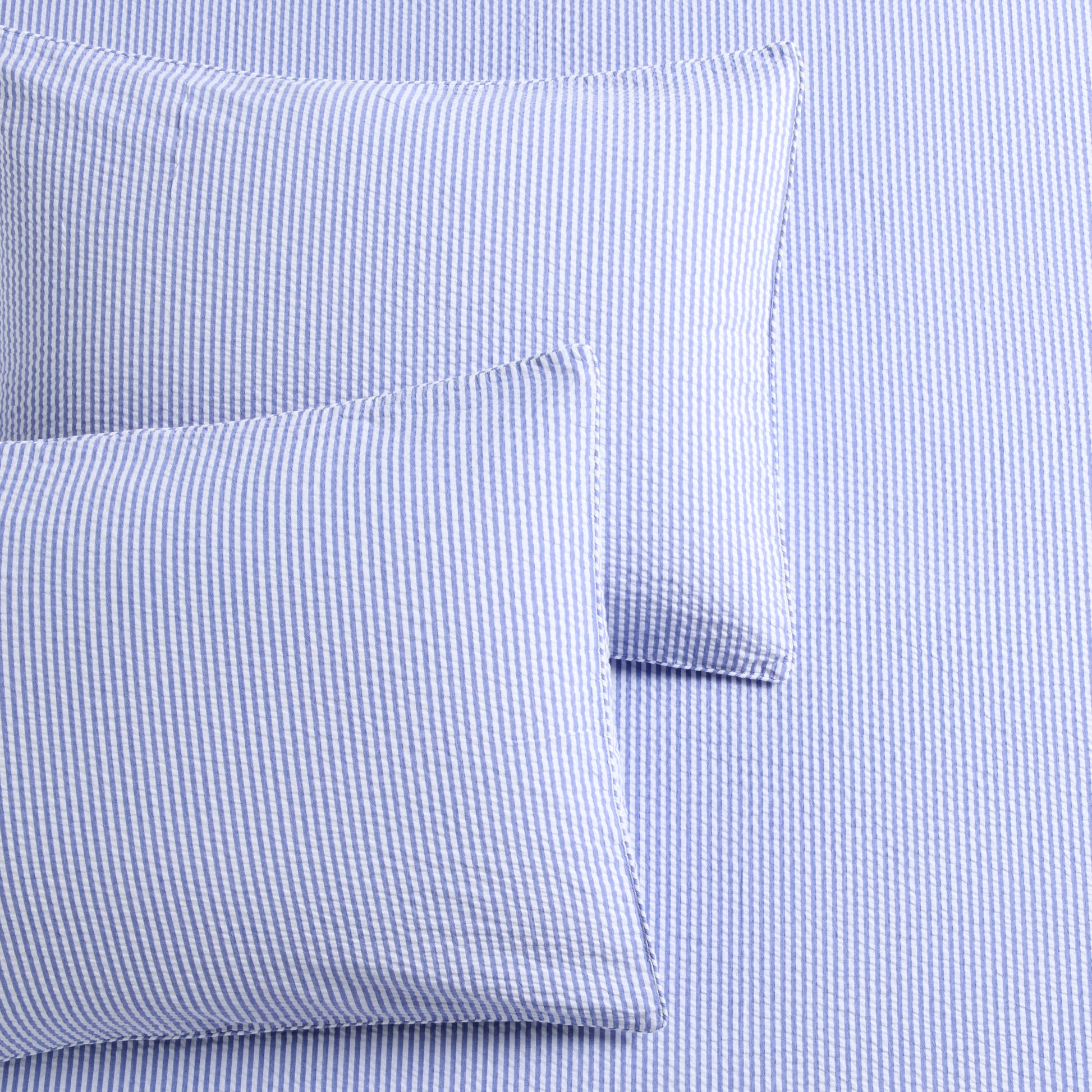 Blue seersucker stripe organic cotton duvet cover and two shams with button and envelope closures.