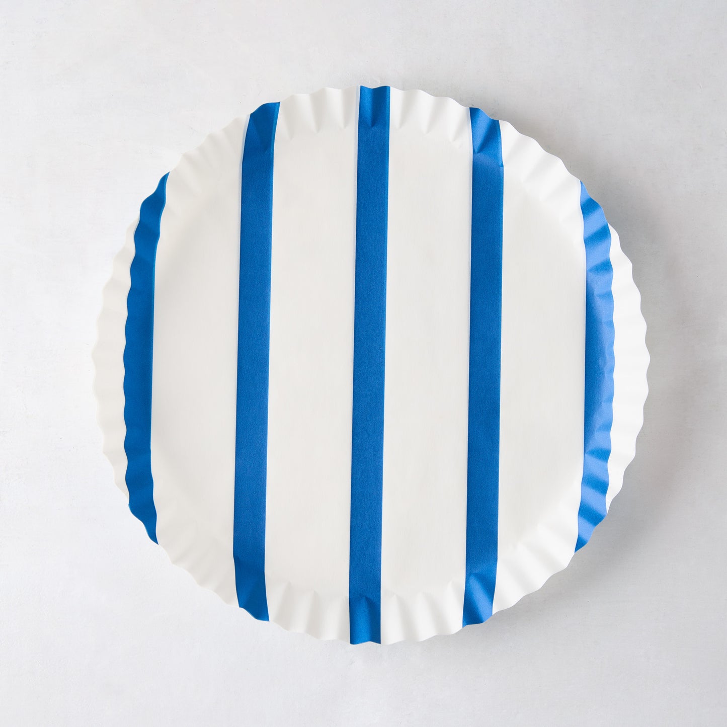 Round white parchment liner with vertical blue stripes and ruffled edges.