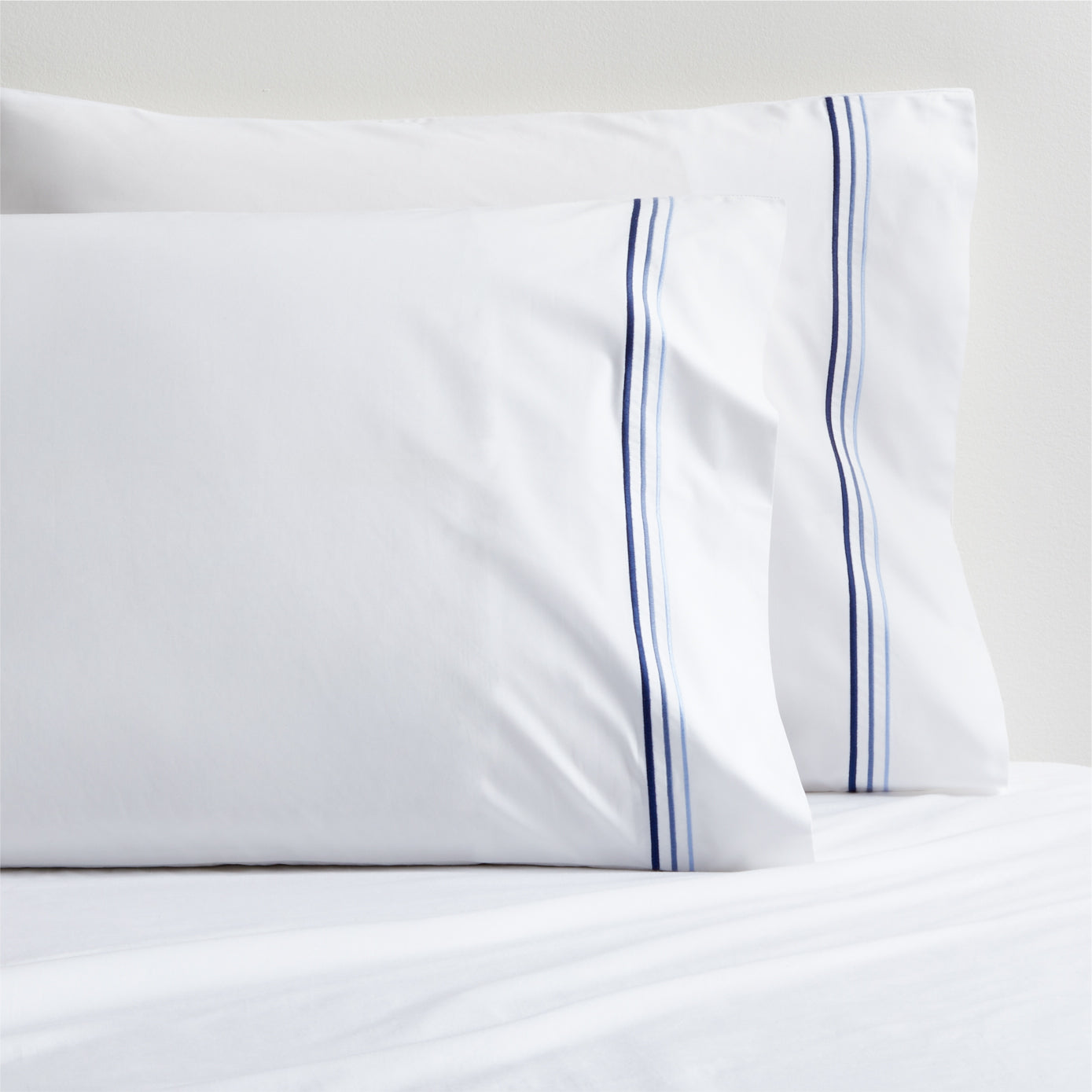 Set of two white percale pillowcases with blue triple-stitch detail.