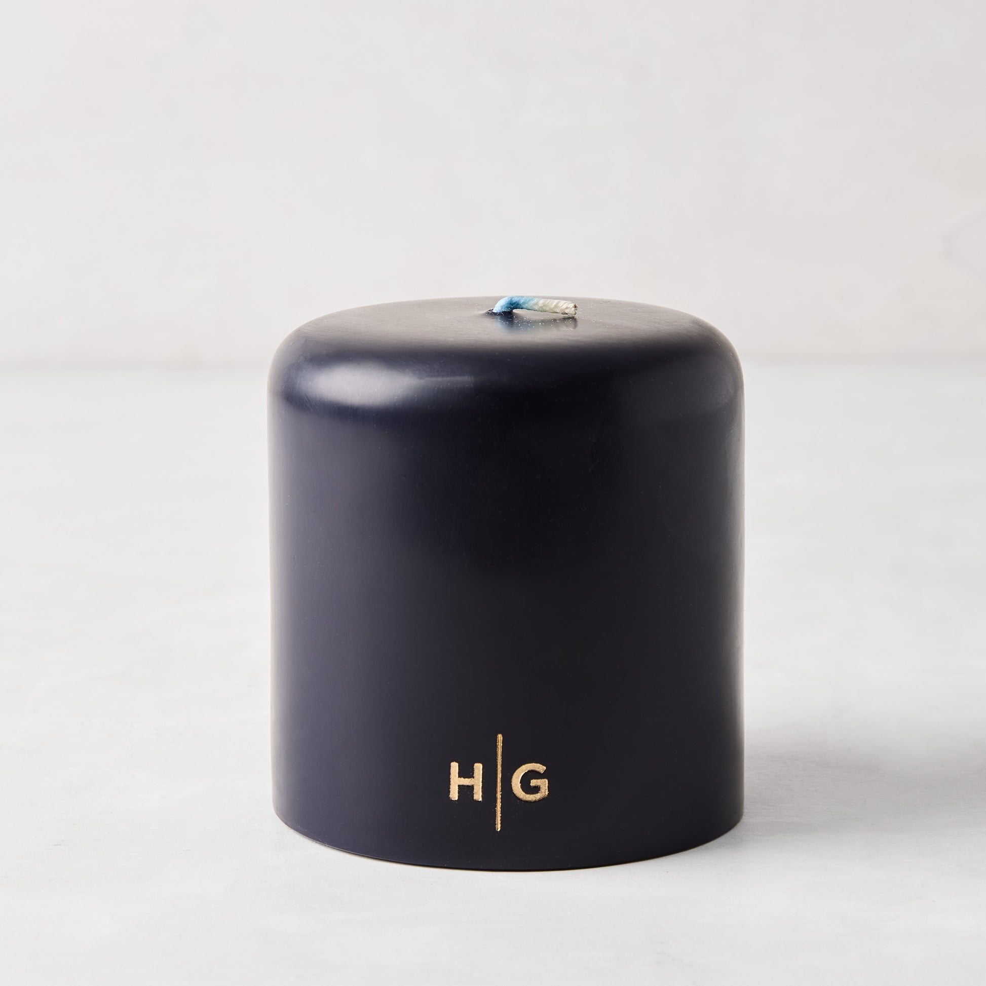 HG Blue Unscented 4x4 pillar candle, hand-dipped paraffin, with gold embossed HG logo and oversized cotton wick.