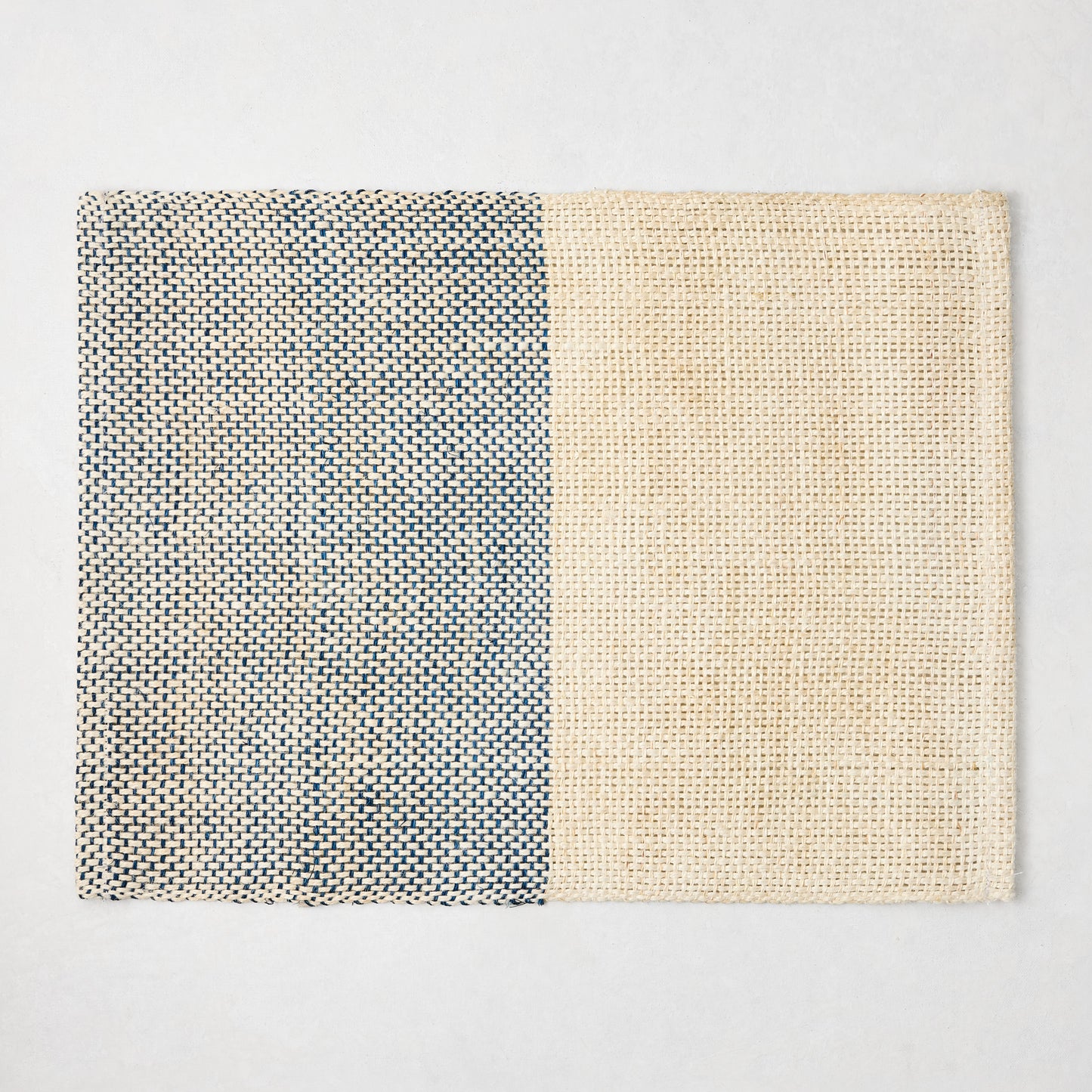 Blue and beige woven abaca and jute rectangular placemat with half and half pattern.