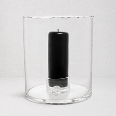 Clear mouth-blown glass hurricane candle holder with a scissor-cut rim and a black pillar candle inside.