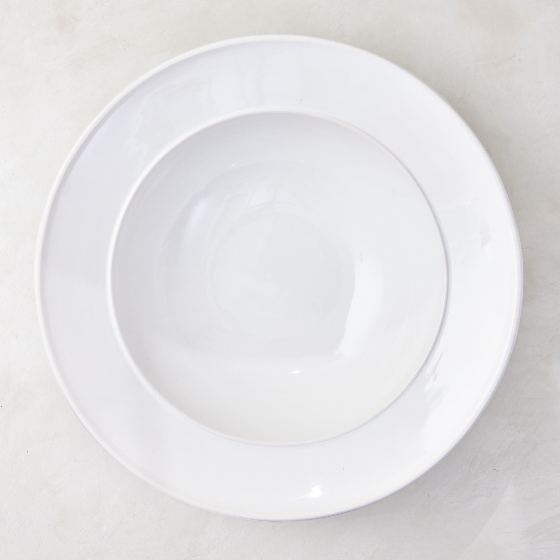 Bolinas 16" white ceramic round serve bowl with a raised edge trim.