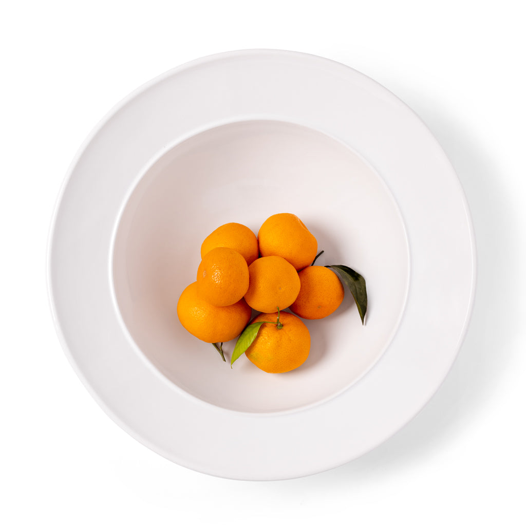 Bolinas white ceramic serve bowl with raised trim, holding tangerines.