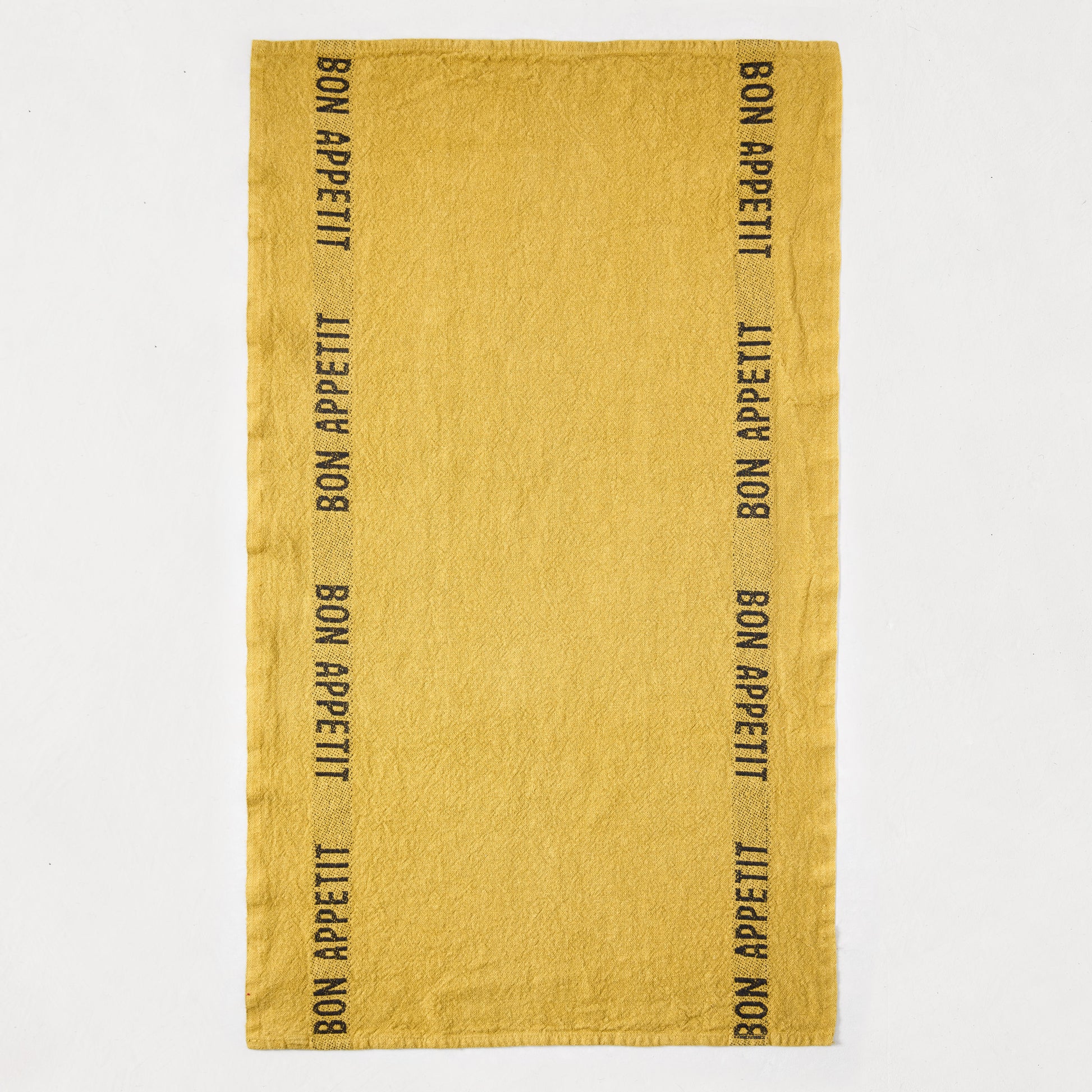 Goldenrod yellow linen hand towel with "Bon Appetit" in black lettering along both long edges.