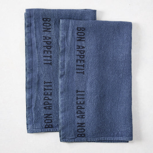 Set of 2 indigo blue linen hand towels with "BON APPETIT" in black lettering.
