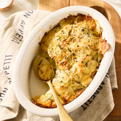 Khaki linen hand towel with "Bon Appetit" in black lettering, draped next to a potato gratin.