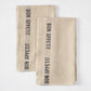 Set of 2 khaki linen hand towels with "BON APPETIT" in black lettering, folded on a white surface.