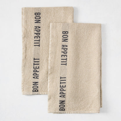 Set of 2 khaki linen hand towels with "BON APPETIT" in black lettering, folded on a white surface.