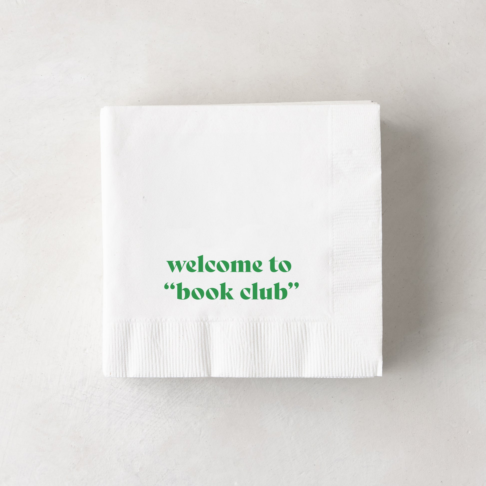 White 3-ply paper cocktail napkins with "welcome to 'book club'" in green text.