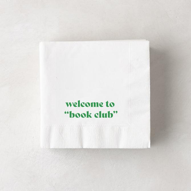 White 3-ply paper cocktail napkins with "welcome to 'book club'" in green text.