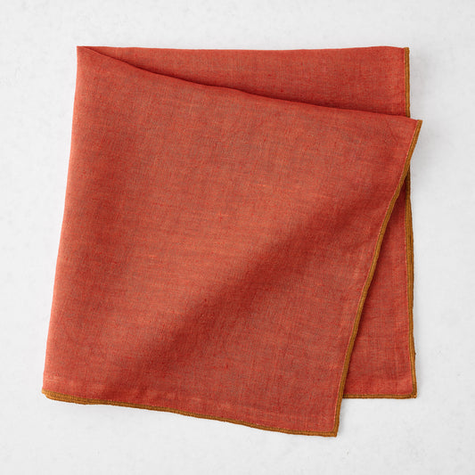 22-inch square brick red linen napkin with contrasting camel brown embroidered tipped stitch edging.