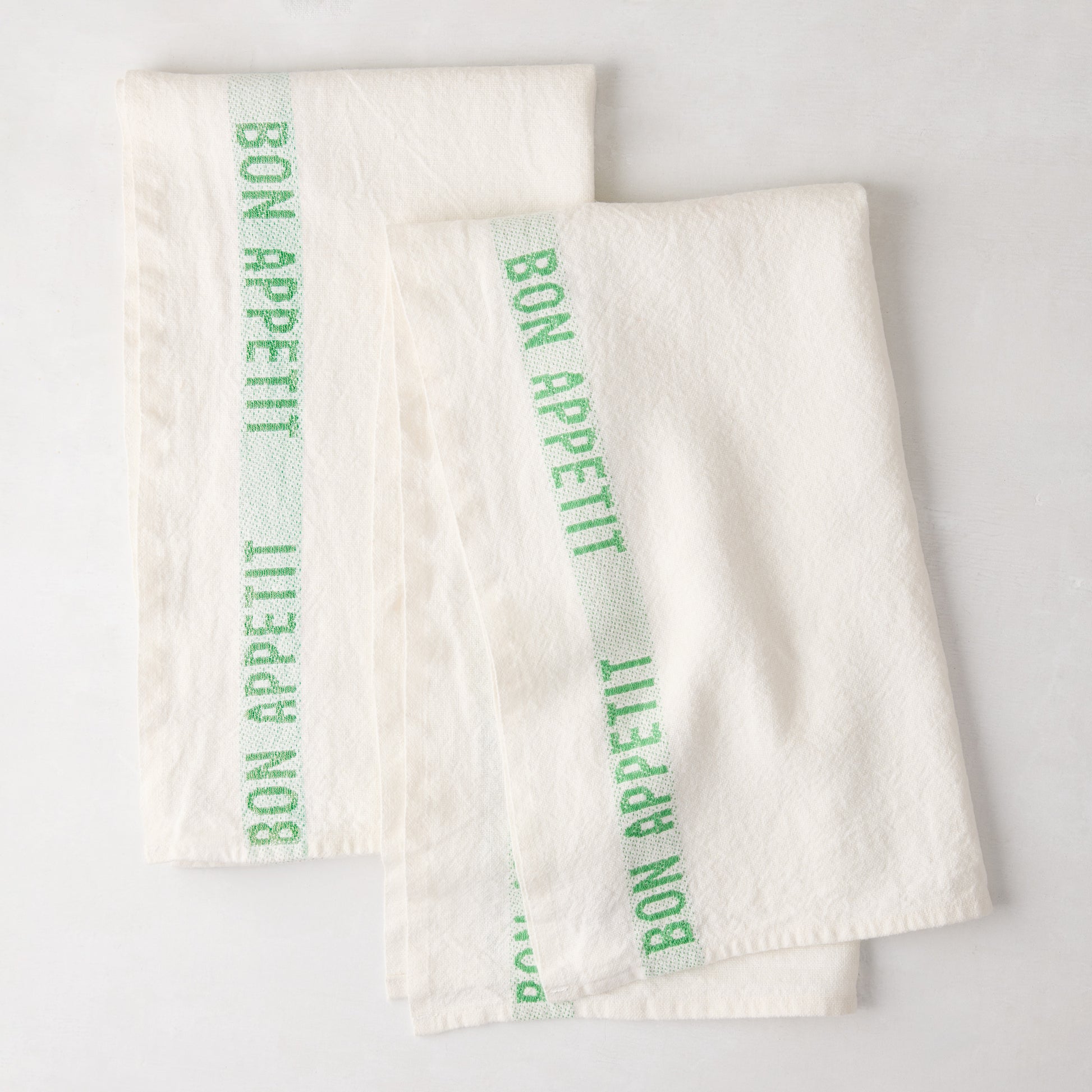 Set of 2 white linen hand towels with a bright green "Bon Appetit" stripe.