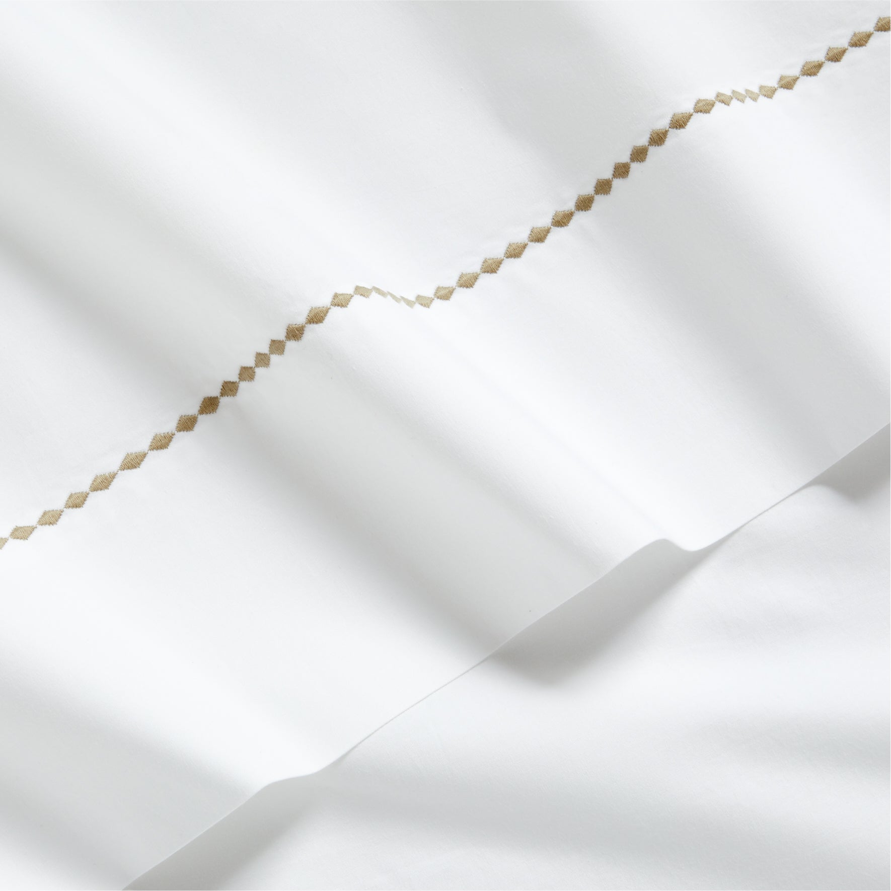 White percale sheet set with brown diamond embroidery detail.