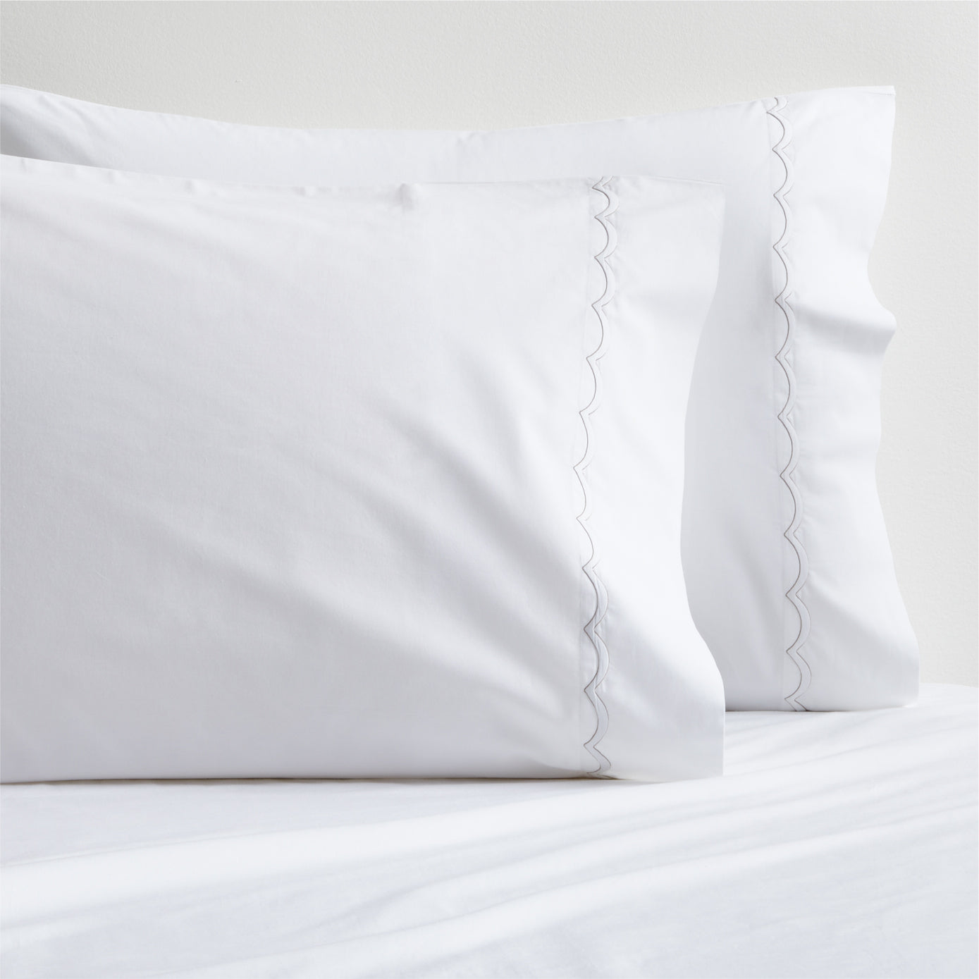 White percale pillowcases with subtle brown scallop-stitch trim, set of two.
