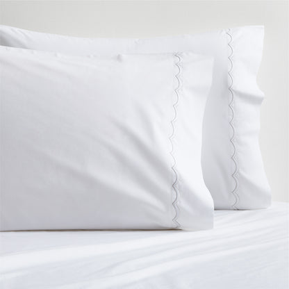 White percale pillowcases with subtle brown scallop-stitch trim, set of two.