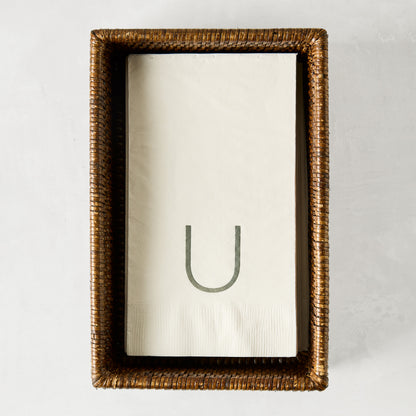 Brown woven rattan rectangular hand towel holder with white folded hand towels.