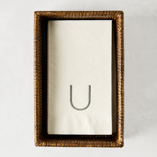 Brown woven rattan rectangular hand towel holder with white folded hand towels.