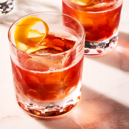 Bubble Eco-Crystal Old Fashioned Glass with a red cocktail and orange peel garnish.