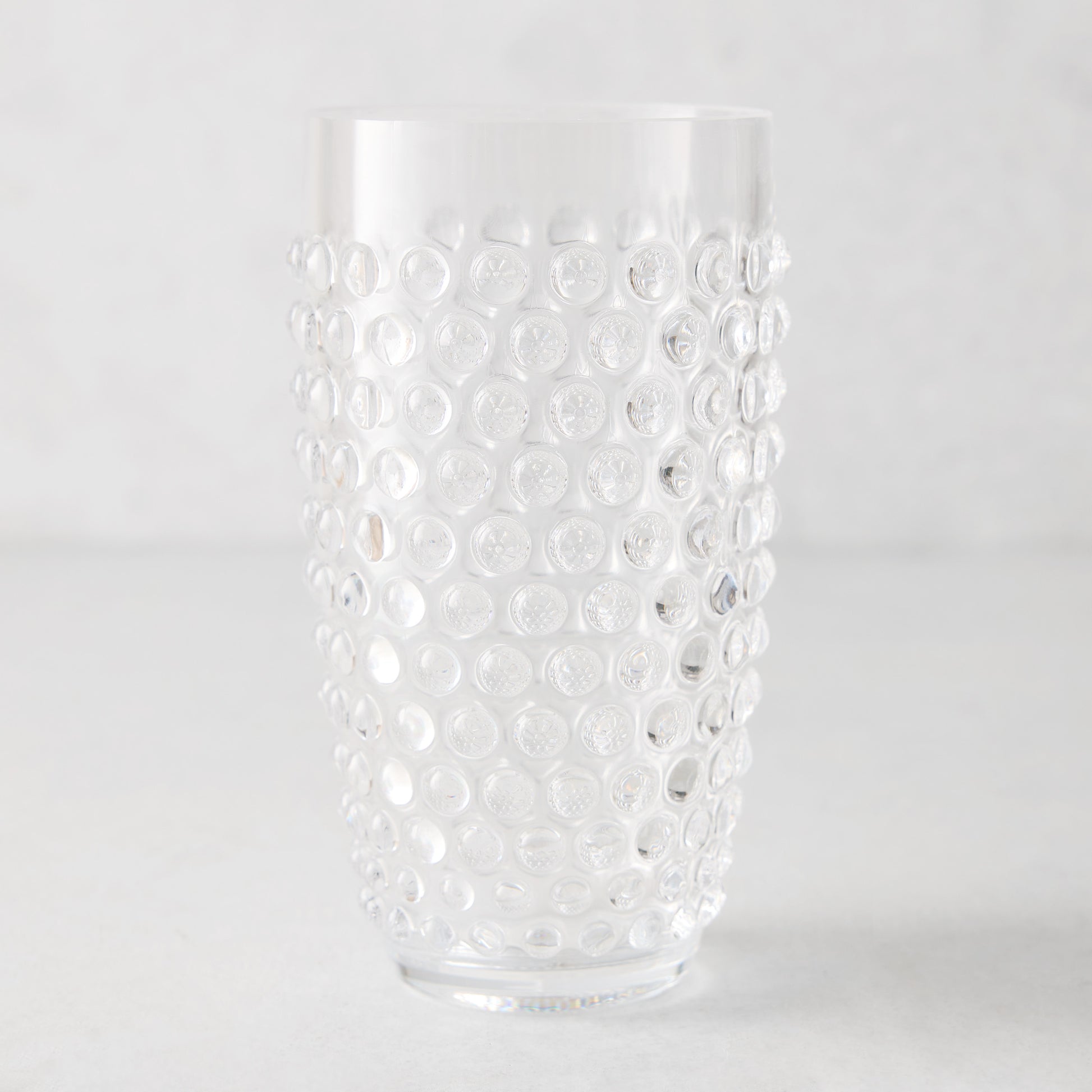Clear bubble acrylic highball glass, 19oz, with textured dot pattern.
