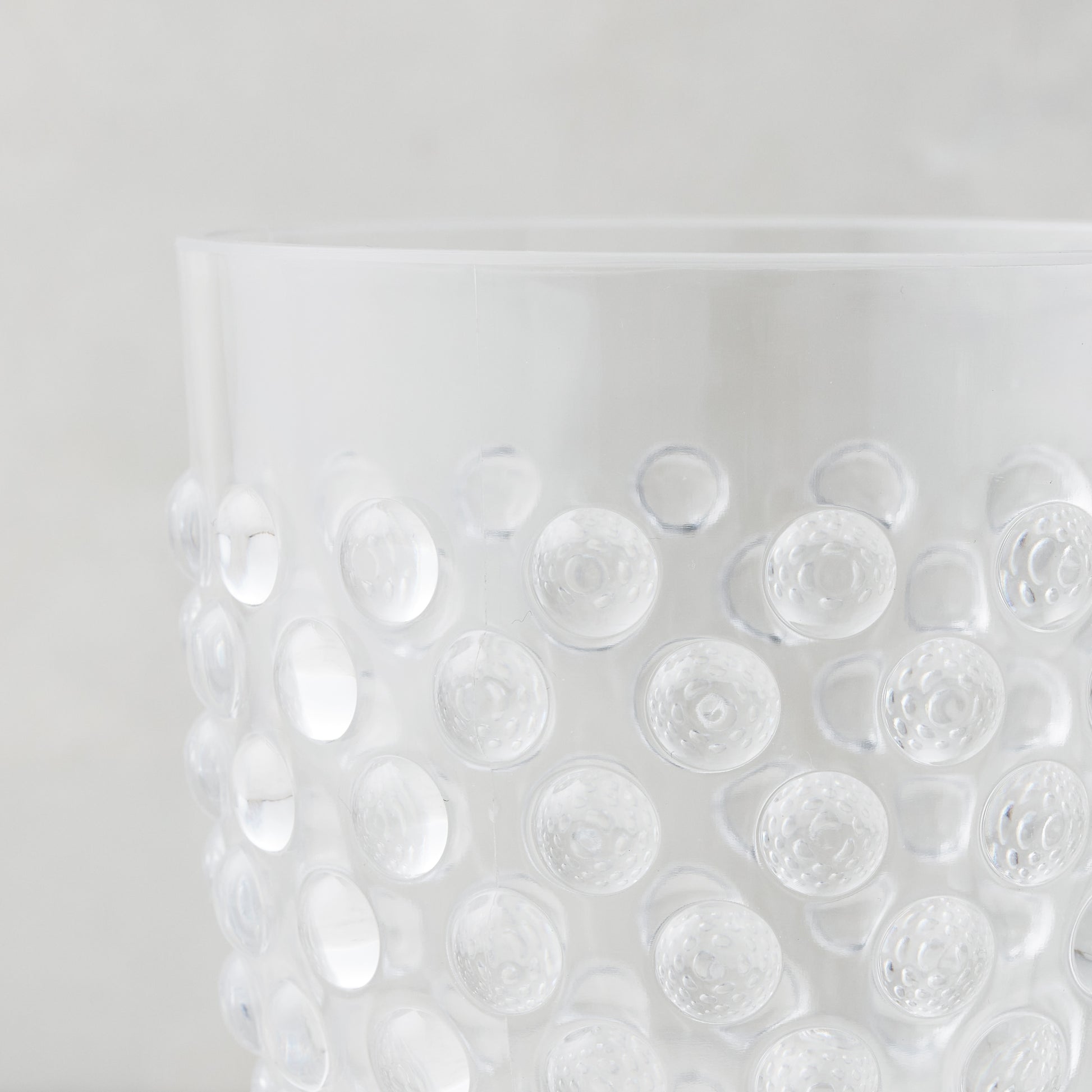 Clear acrylic wine glass with a textured bubble design.