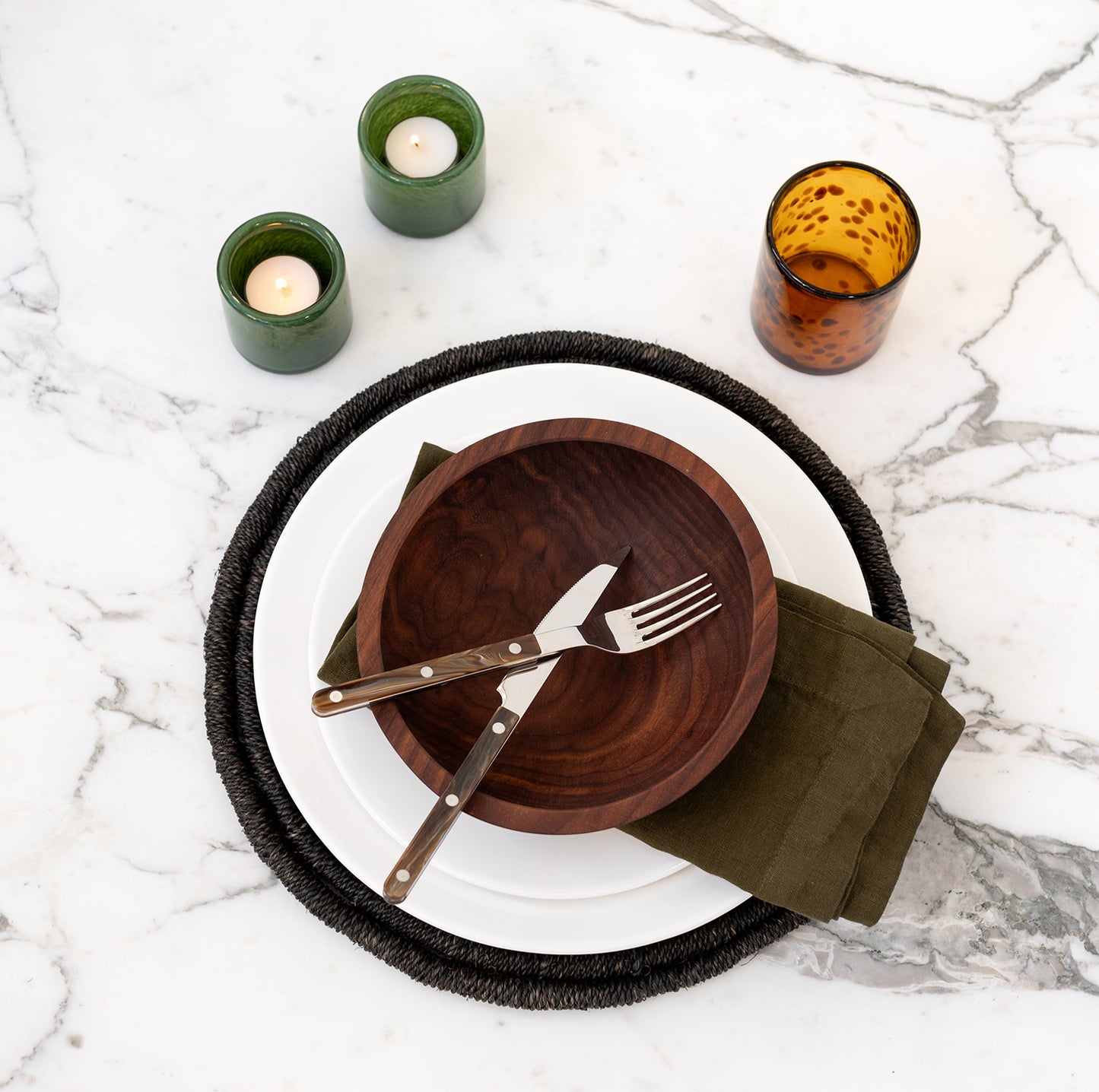 Buffalo Bistro 5-piece flatware set with brown acrylic handles on a white plate, dark wood bowl, and green napkin.