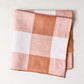 Folded 20"x20" Spice Orange Buffalo Check Linen Napkin with light ginger orange and white squares.