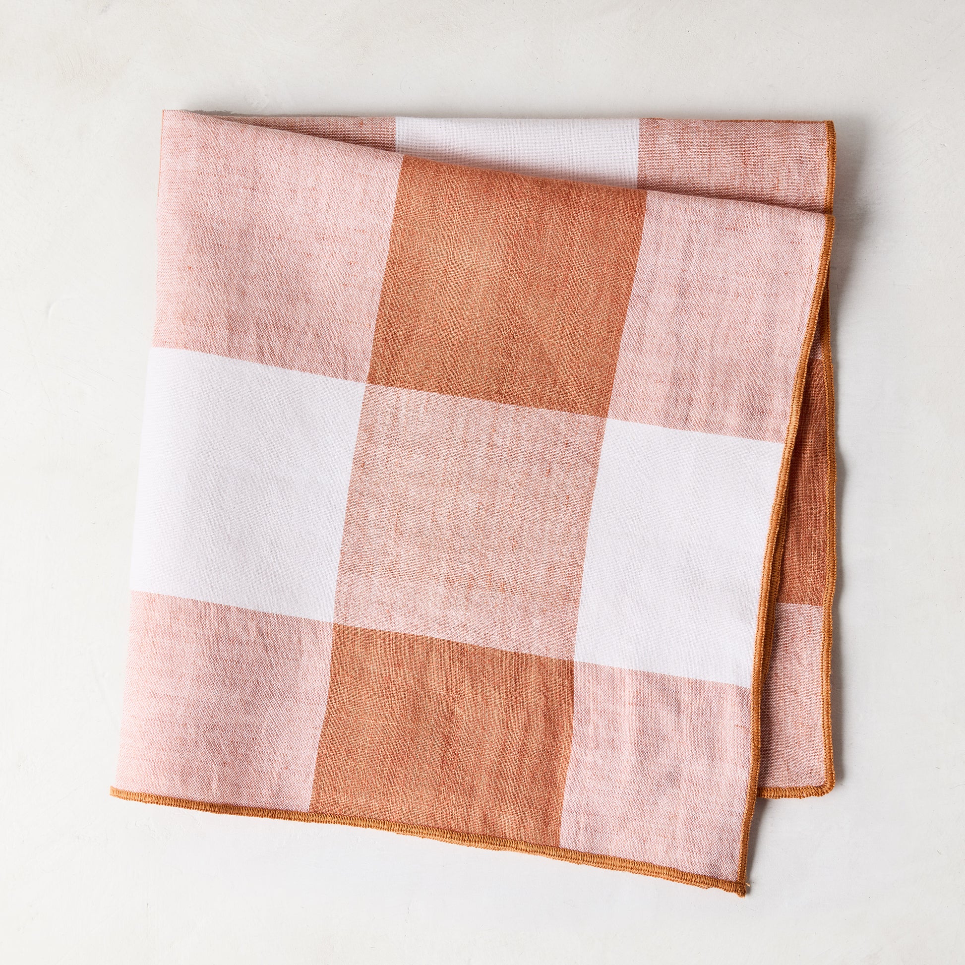 Folded 20"x20" Spice Orange Buffalo Check Linen Napkin with light ginger orange and white squares.