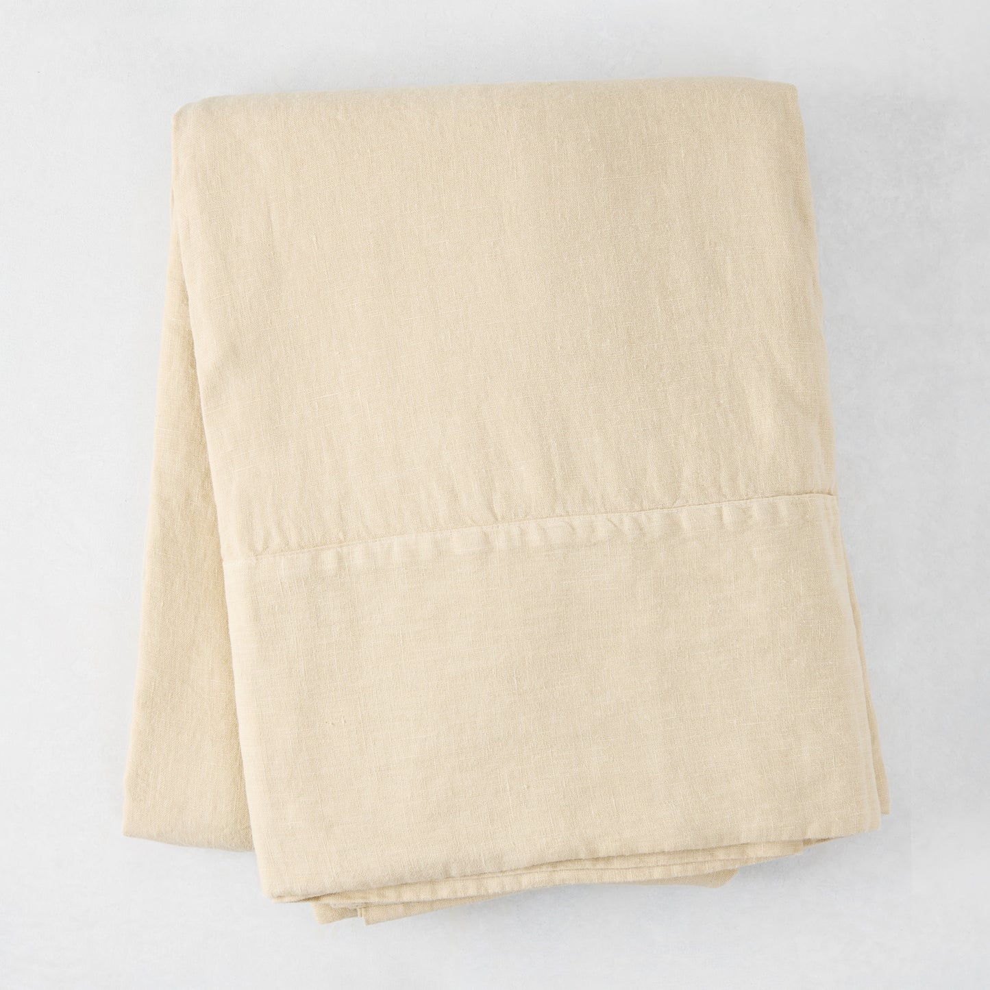 Folded Buttermilk HG Signature Hand-Dyed Linen Tablecloth, 70" x 126", soft khaki color.