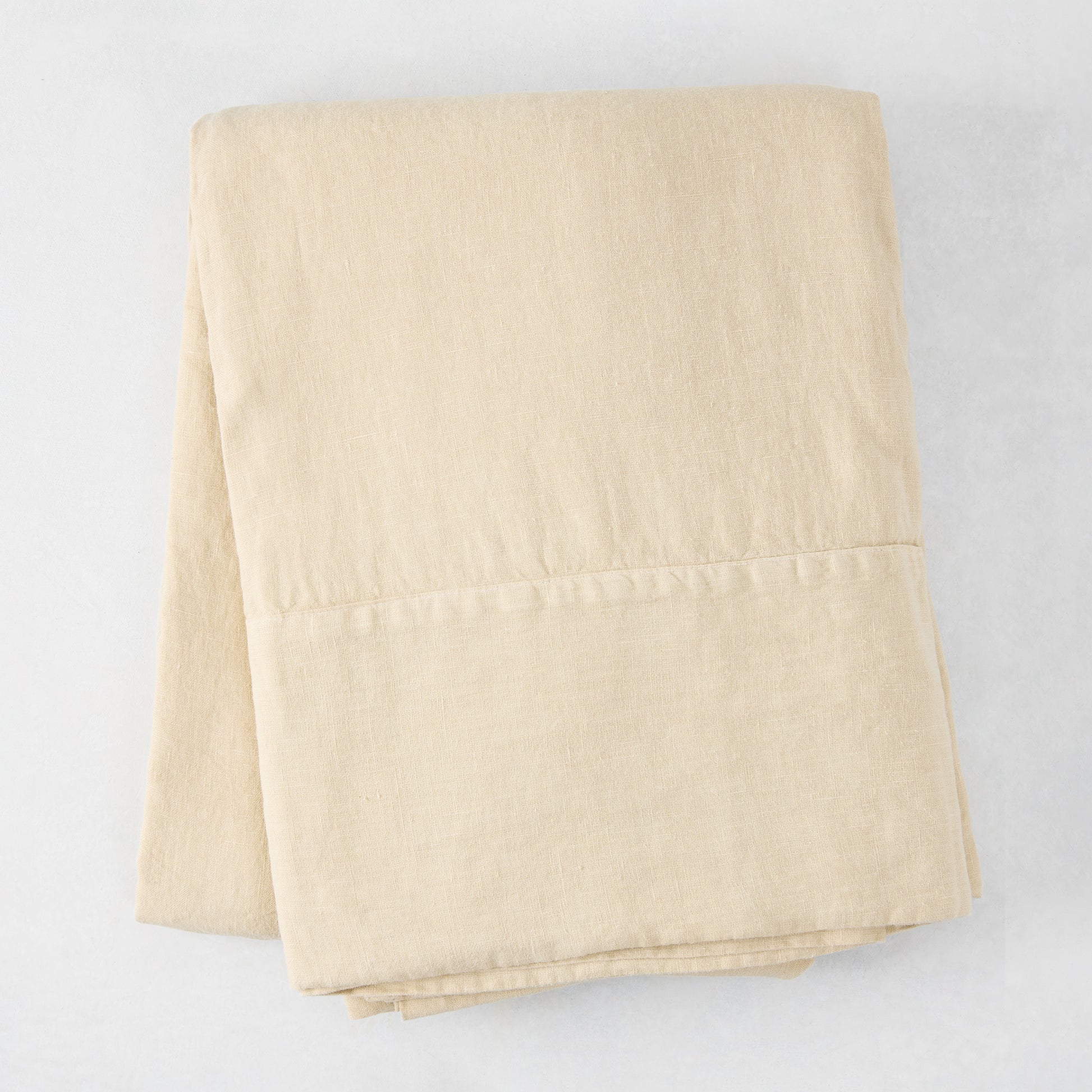 Folded Buttermilk HG Signature Hand-Dyed Linen Tablecloth, 70" x 126", soft khaki color.