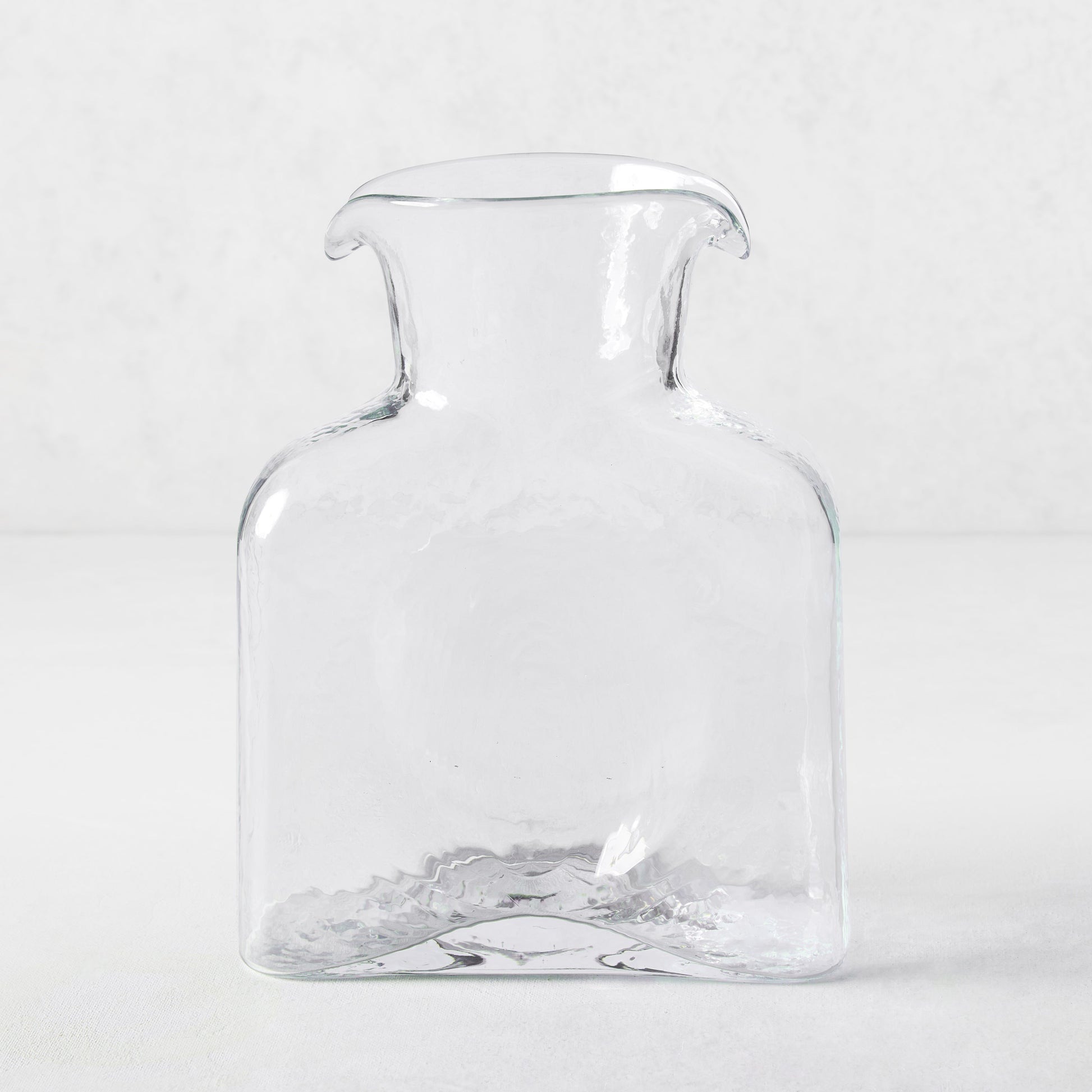 Cabell Square Glass Pitcher, clear hand-blown glass, 8"H, with dual spouts and textured finish.