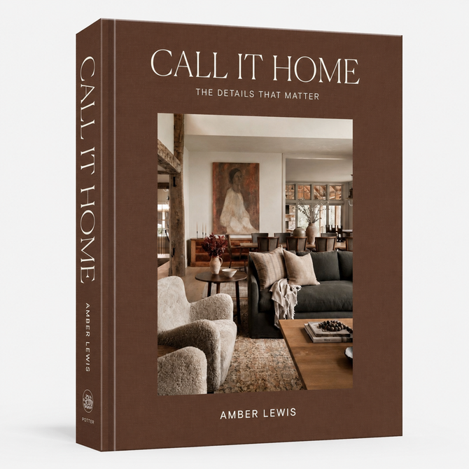 The front and spine of the book 'Call It Home: The Details That Matter' by Amber Lewis, featuring a warm brown cover with a central photograph of a cozy living room.