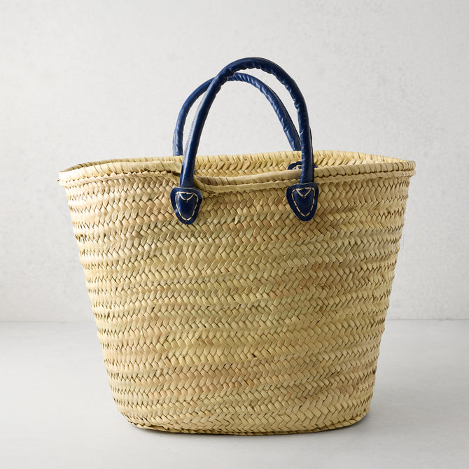 Capri Blue Handled Woven Tote Bag, natural palm grass with navy blue leather handles.