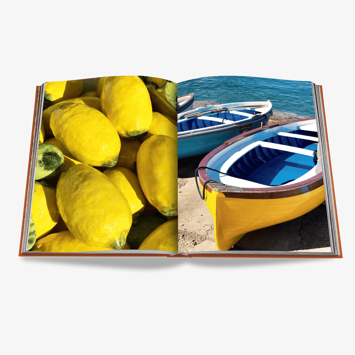 Open "Capri Dolce Vita" book showing vibrant lemons on left, yellow and blue boats by the sea on right.