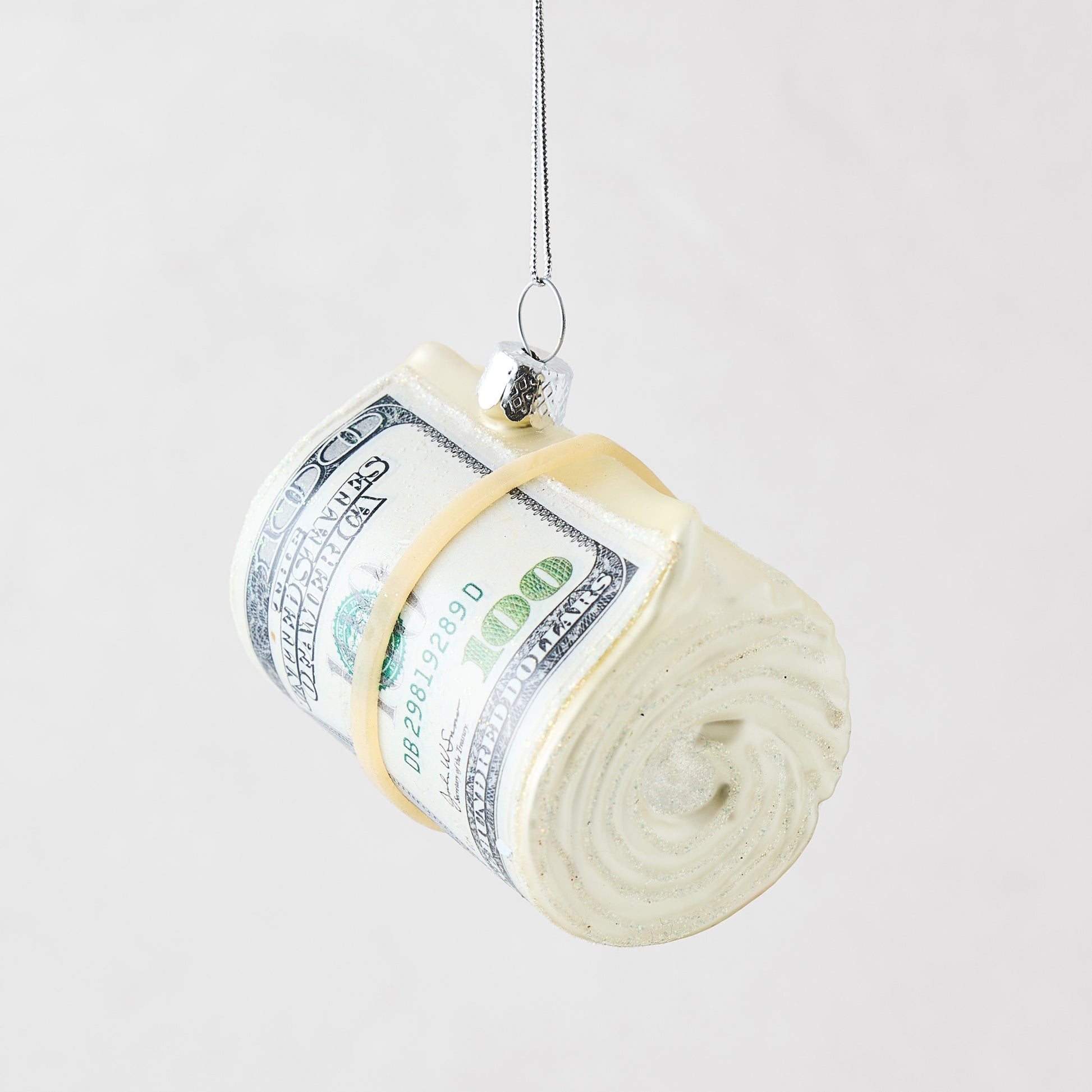 Hand-painted glass and resin cash roll Christmas ornament with glitter accents and a silver hanging loop.