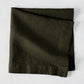 Cedar HG Signature Hand-Dyed Linen Napkin, dark mossy green, folded square, 22-inch.
