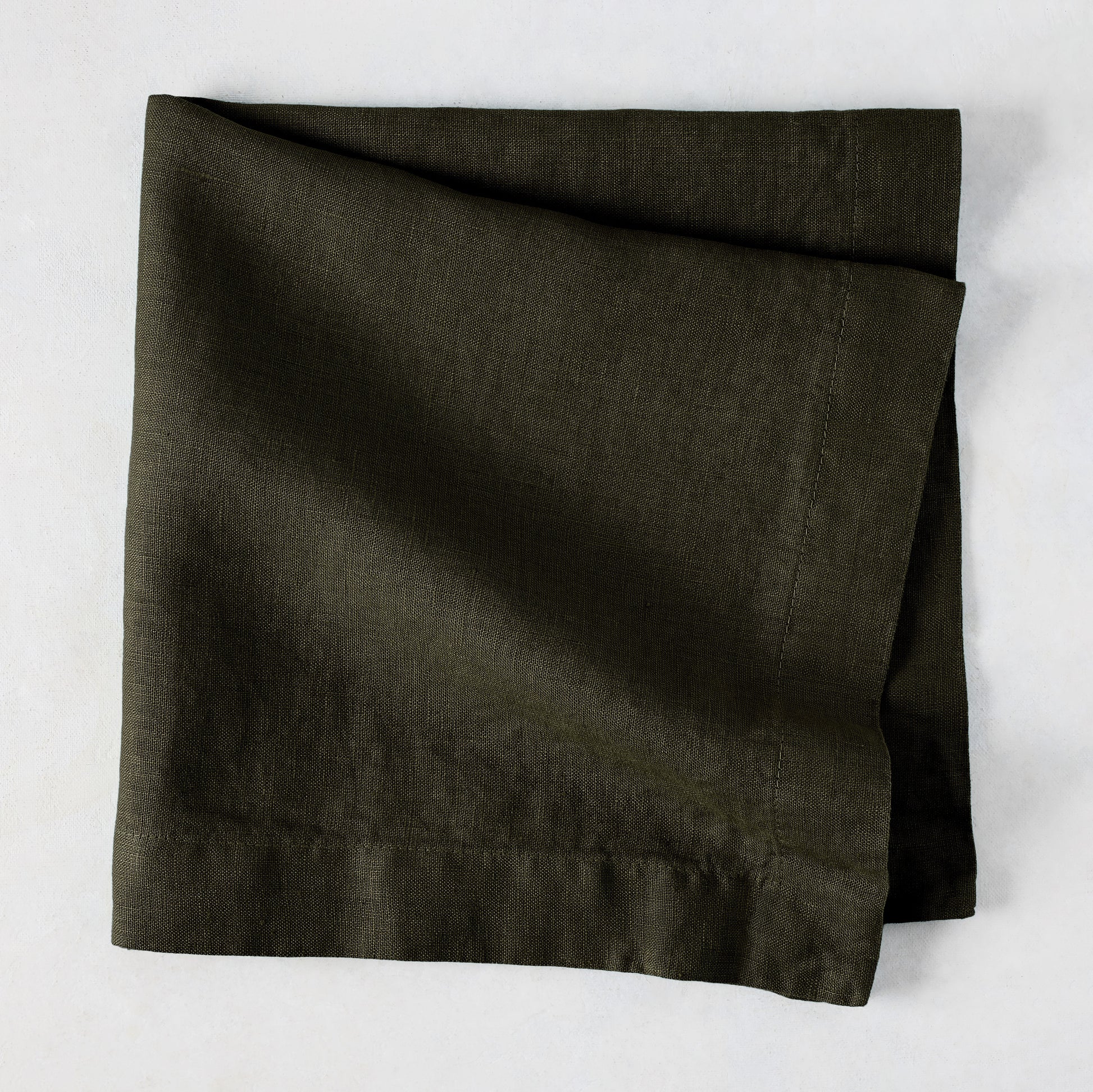 Cedar HG Signature Hand-Dyed Linen Napkin, dark mossy green, folded square, 22-inch.