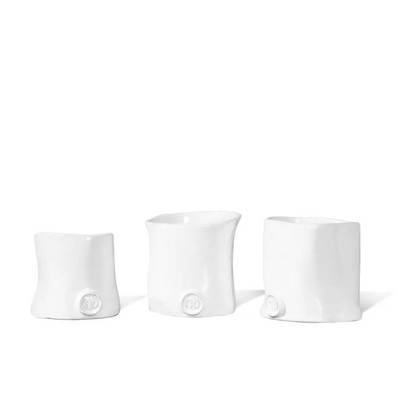 Three handmade Montes Doggett ceramic appetizer bowls in creamy white glaze, varying sizes.