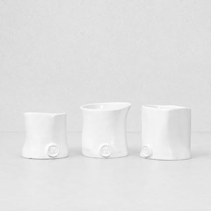 Three handmade Montes Doggett ceramic appetizer bowls in creamy white glaze.