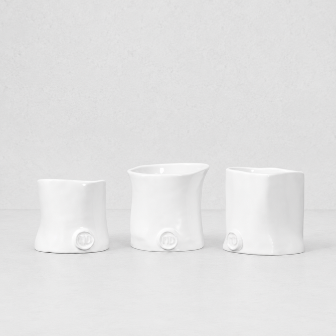 Three handmade Montes Doggett ceramic appetizer bowls in creamy white glaze.