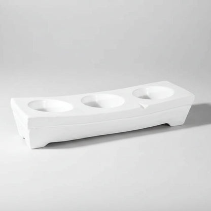 White ceramic appetizer platform by Montes Doggett, 17.25"L, with three round dip wells.