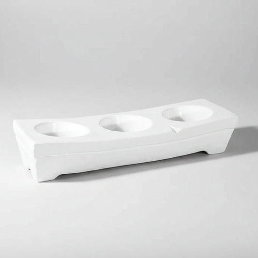 White ceramic appetizer platform by Montes Doggett, 17.25"L, with three round dip wells.
