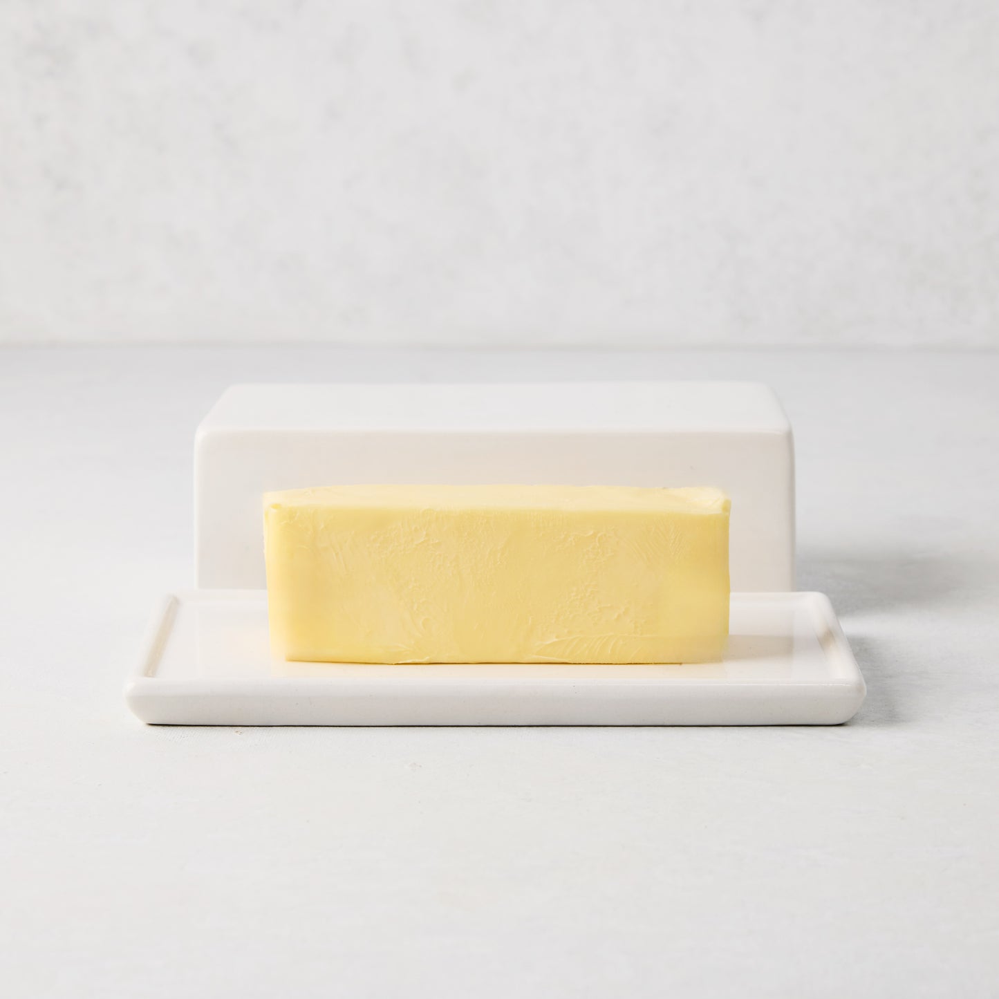 White ceramic HG butter dish with lid and a stick of European butter.